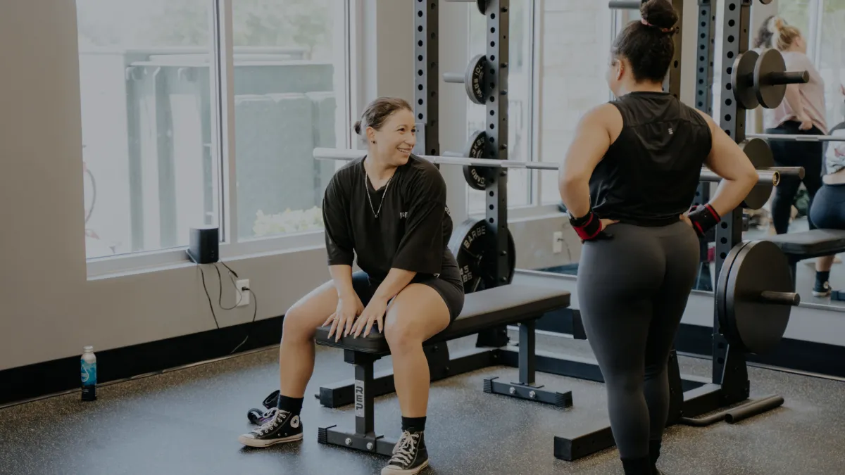 person standing beside black weights
