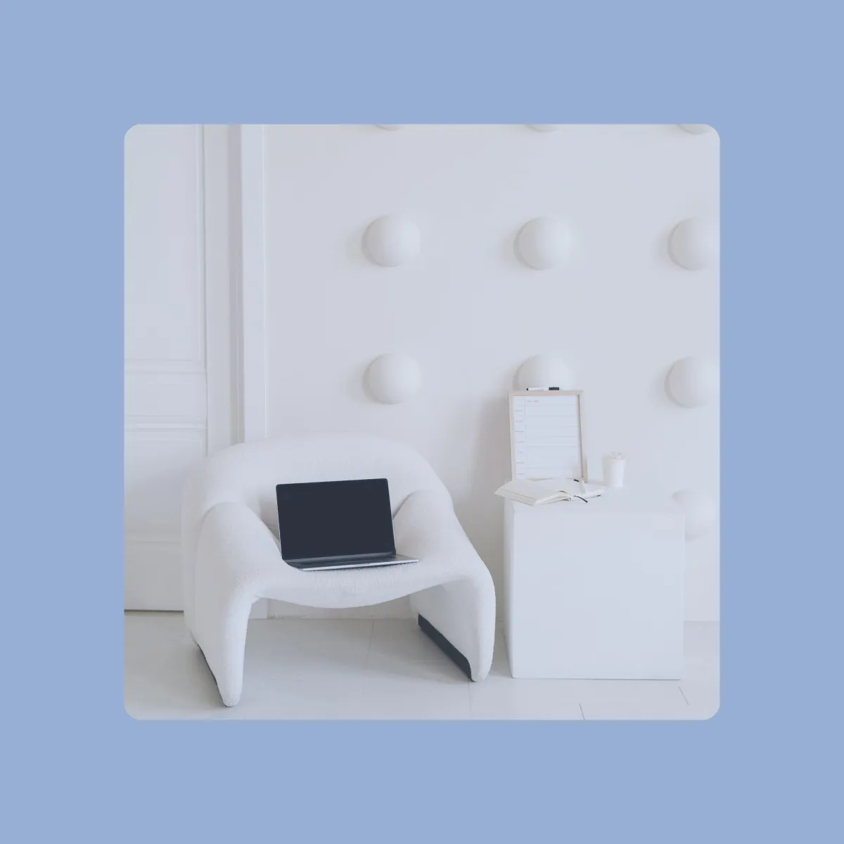 modern white office setup with laptop on boucle chair