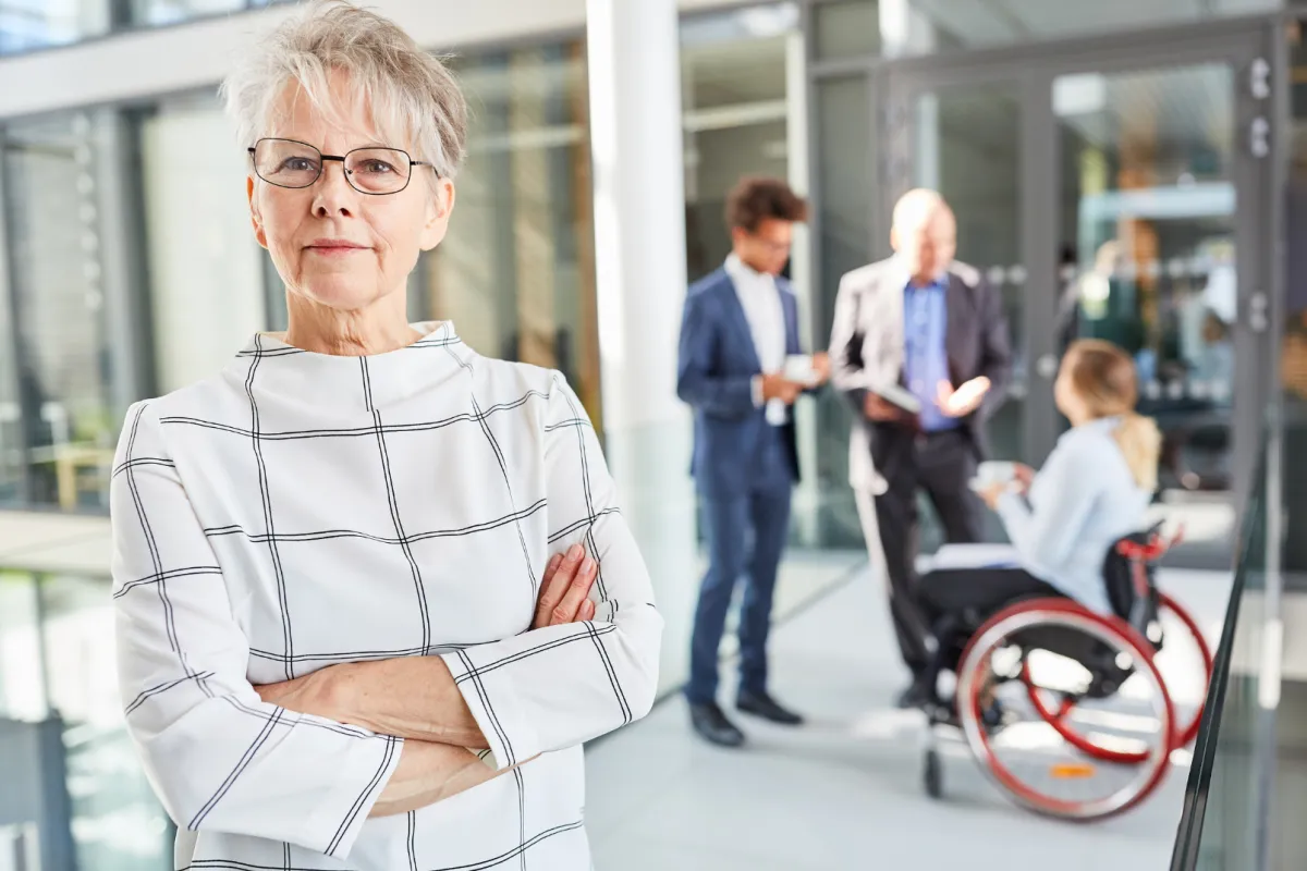 Woman business owner with employees in background