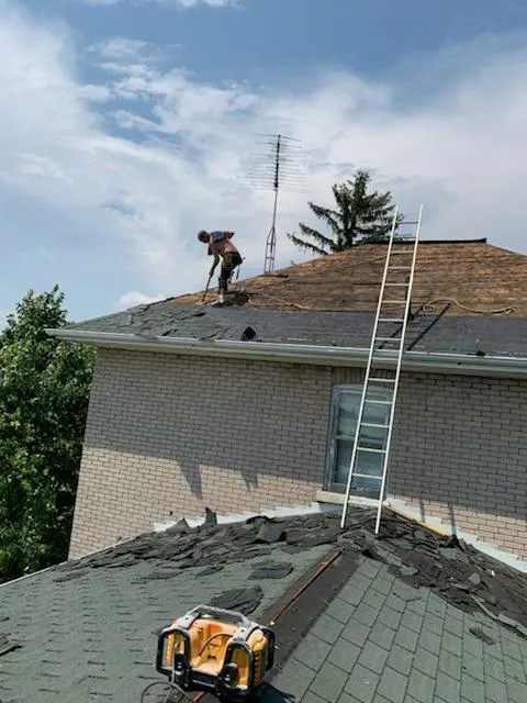 Gutter replacement with new seamless aluminum gutters and downspouts directing water away from the foundation.