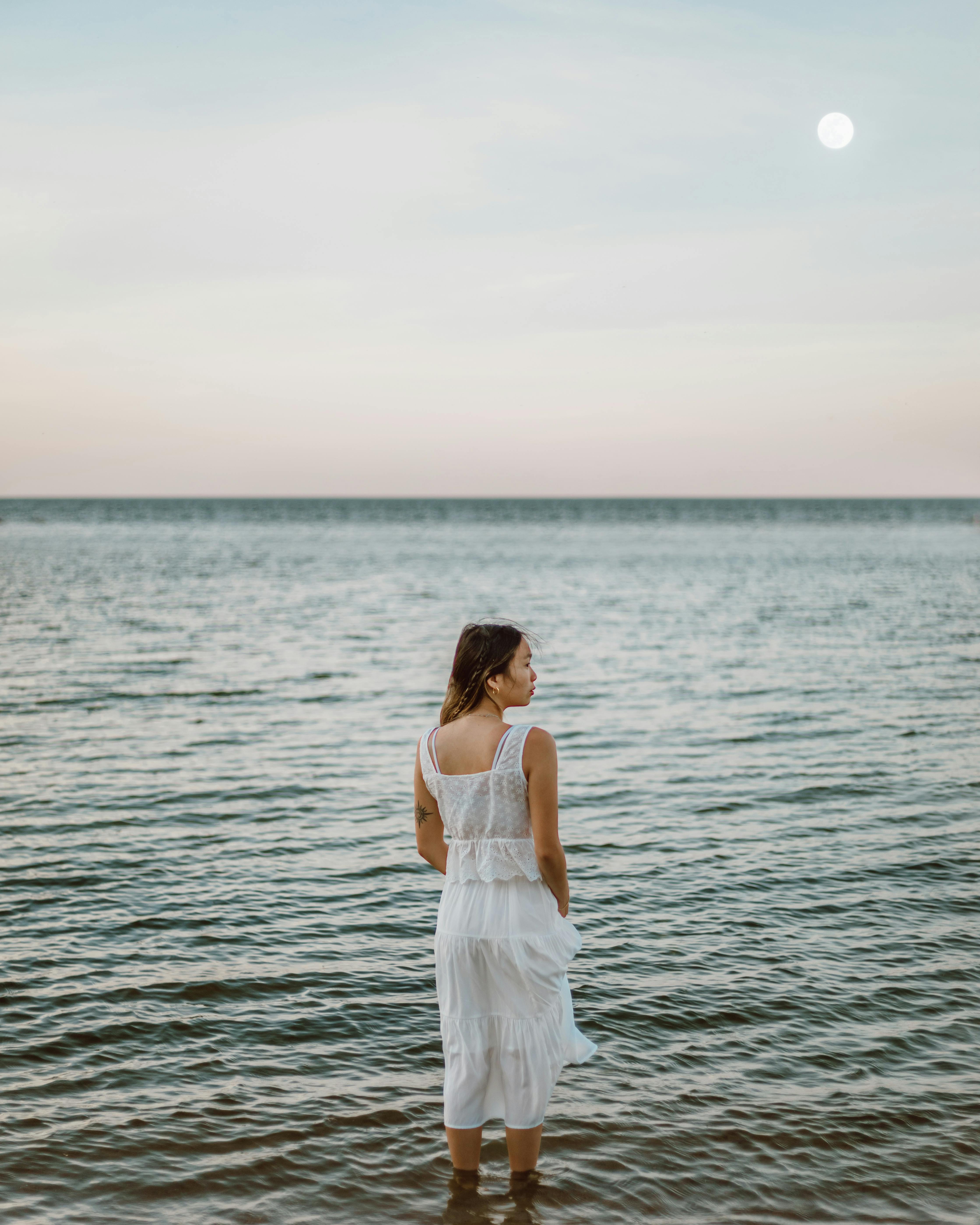 Woman standing calmly in the ocean, reflecting confidence and emotional balance during menopause.