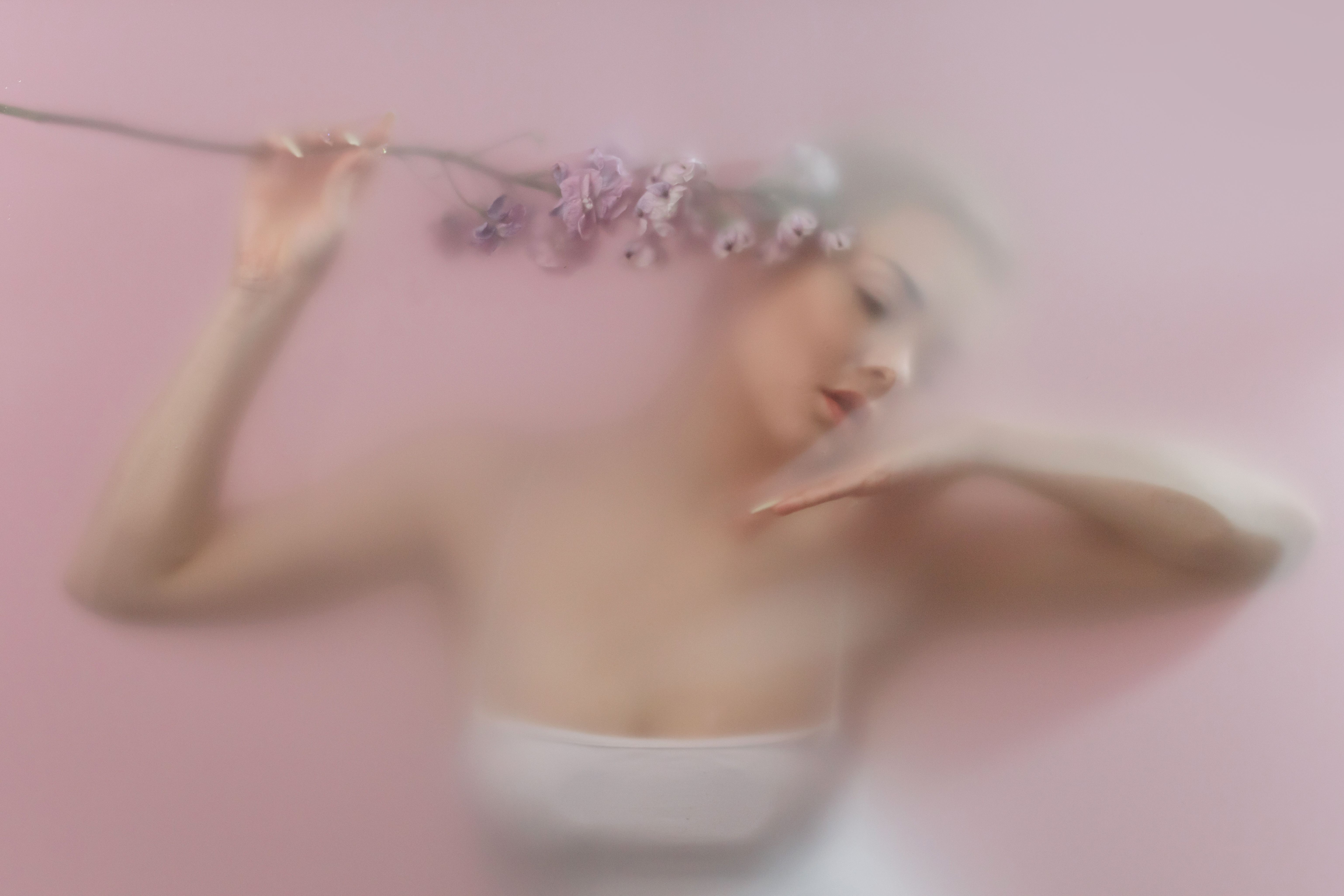Woman holding delicate flowers, representing vaginal health, wellness, and personalized women’s care.
