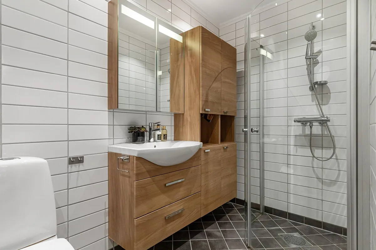 white tiled wall and black tiled bathroo mfloor