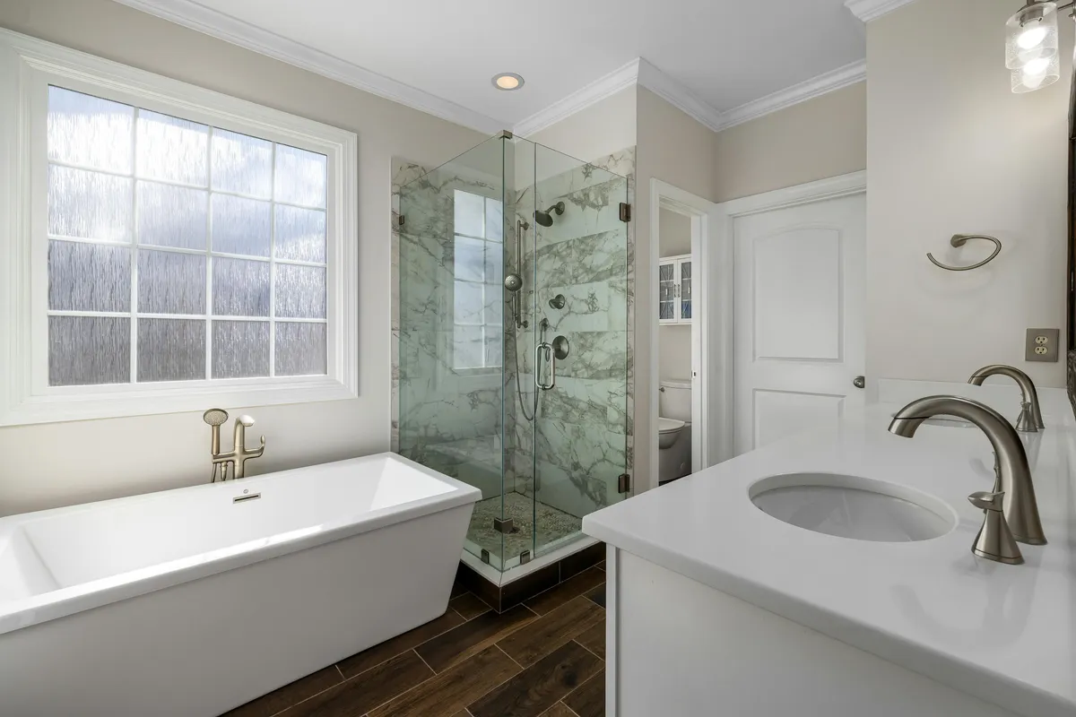 beige bathroom with bathtub, shower and sink vanity