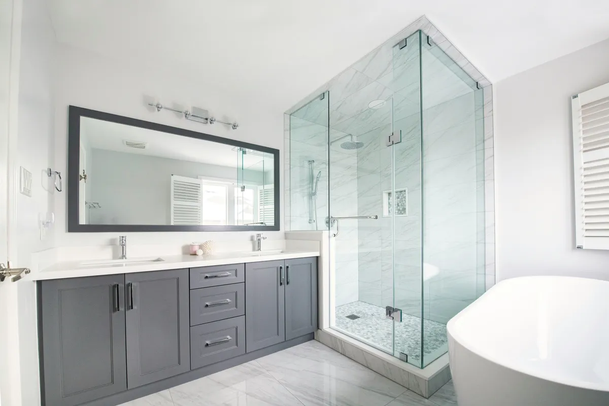 open white and grey coloured bathroom with big vanity, mirror and shower