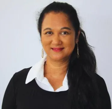Female therapist smiling with confidence, offering effective hypnosis and wellness solutions for mental well-being.