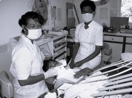 Healthcare professionals in a dental office providing patient care with gentle hands and advanced tools.