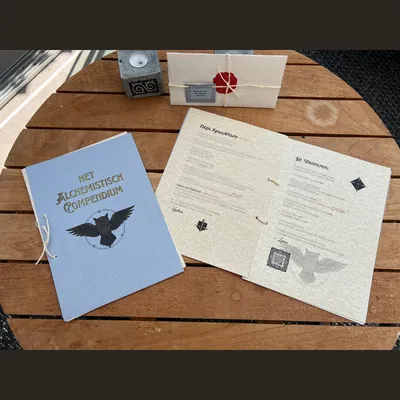 Het Alchemistisch Compendium open en dicht van het denkspel Het Erfgoed - Het Obsidiaan Ei.