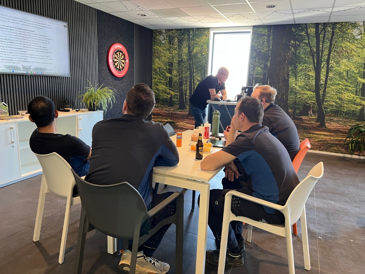 Medewerkers van GPI-Elektrotechniek spelen het B2B teambuildingspel Het Obsidiaan Ei aan tafel op locatie