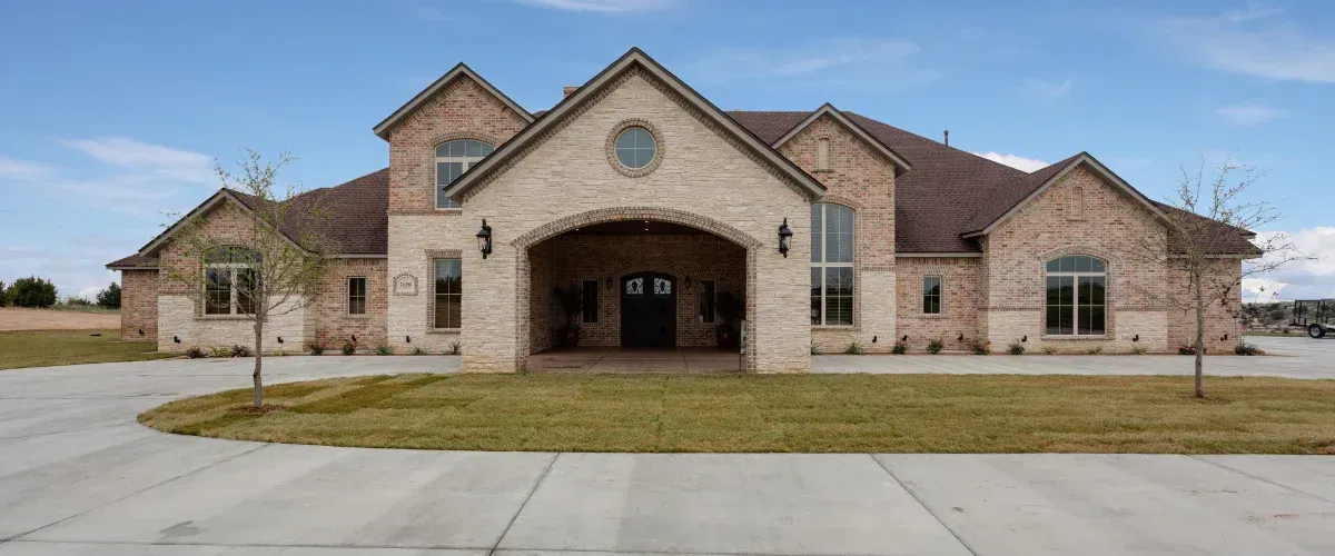 Large residential building with clean exterior and well maintained driveway