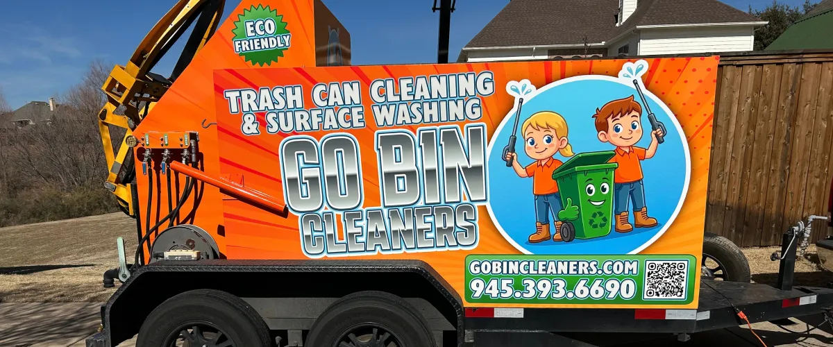 A bright orange Go Bin Cleaners trailer with "Trash Can Cleaning & Surface Washing" text and cartoon characters.