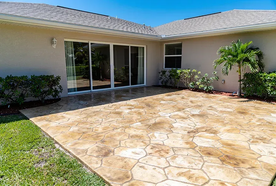 Stamped concrete patio with a stone-pattern finish at a home in Lake Worth, Florida on a sunny day.