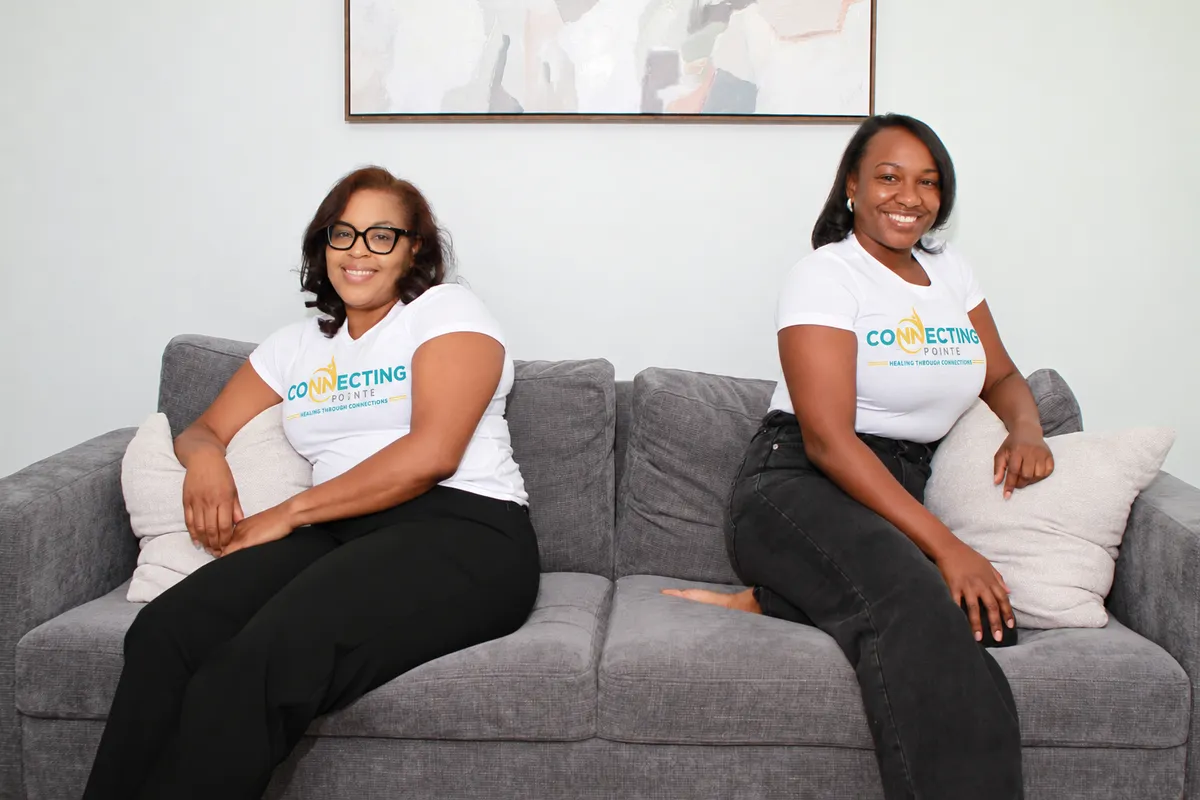 Resnee and Donielle seated together in Connecting Pointe shirts