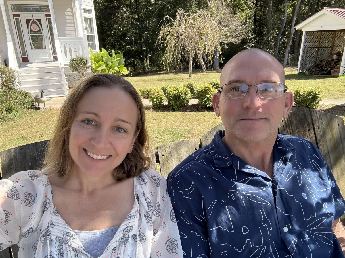 Misty and Mike standing on a scenic property with their dogs