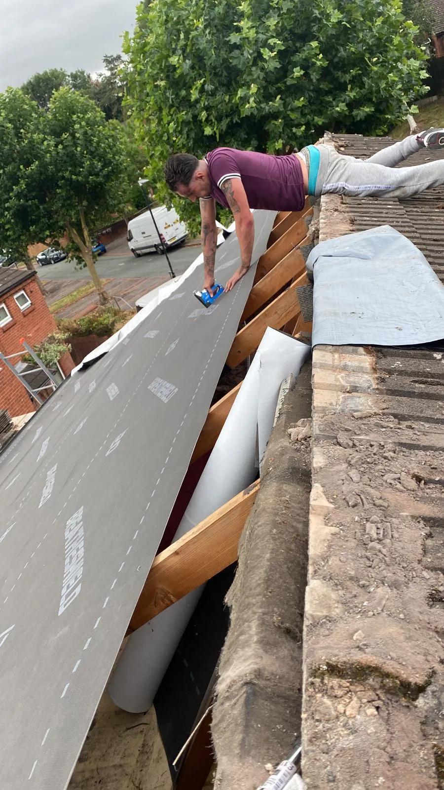 JF Roofers team member carefully laying roof tiles, demonstrating meticulous attention to detail and high-quality craftsmanship to ensure a durable and well-finished roofing solution.