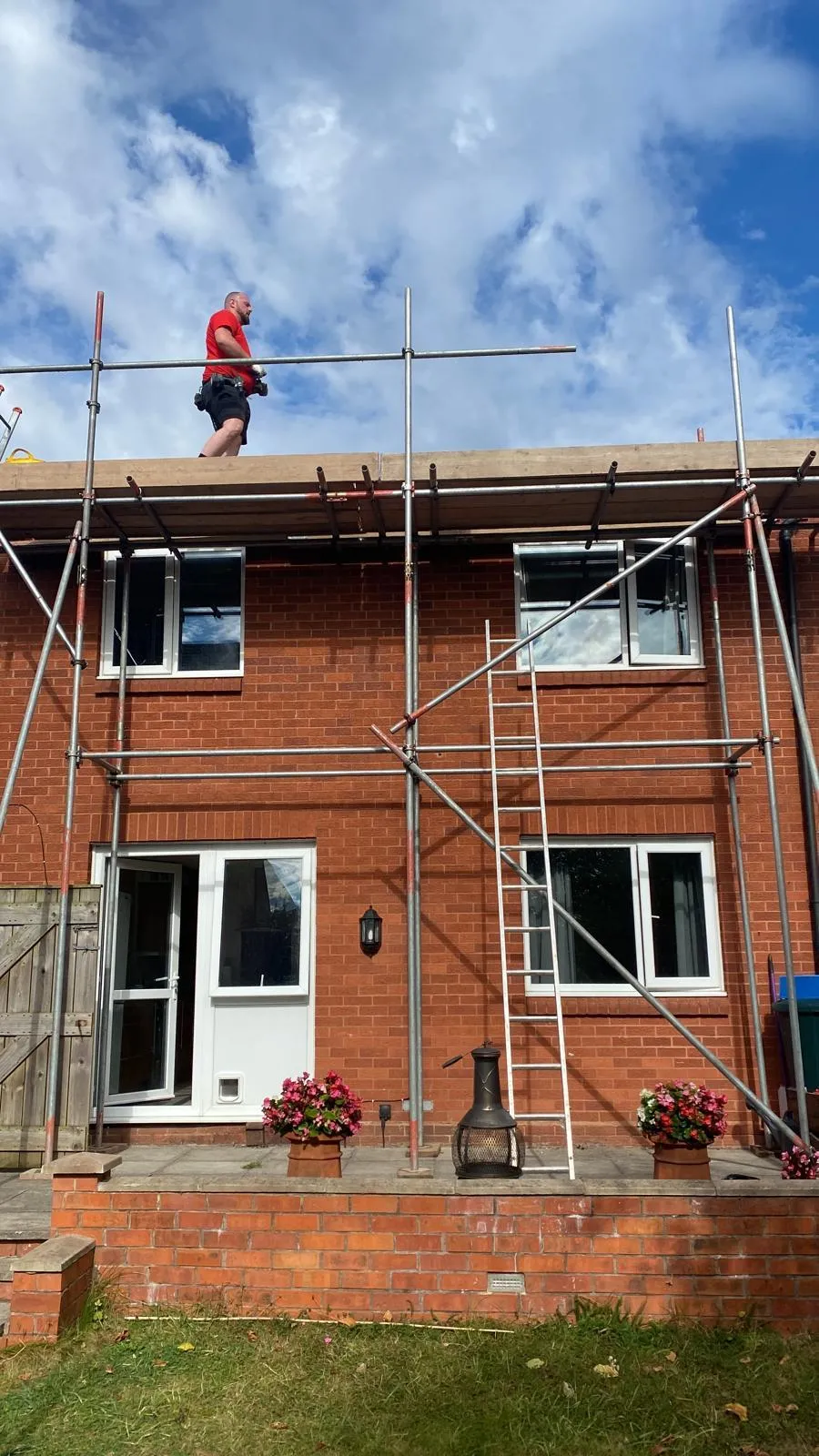 Roofer on scaffolding preparing for a thorough roof inspection, ensuring safety and readiness for a detailed assessment by JF Roofers.