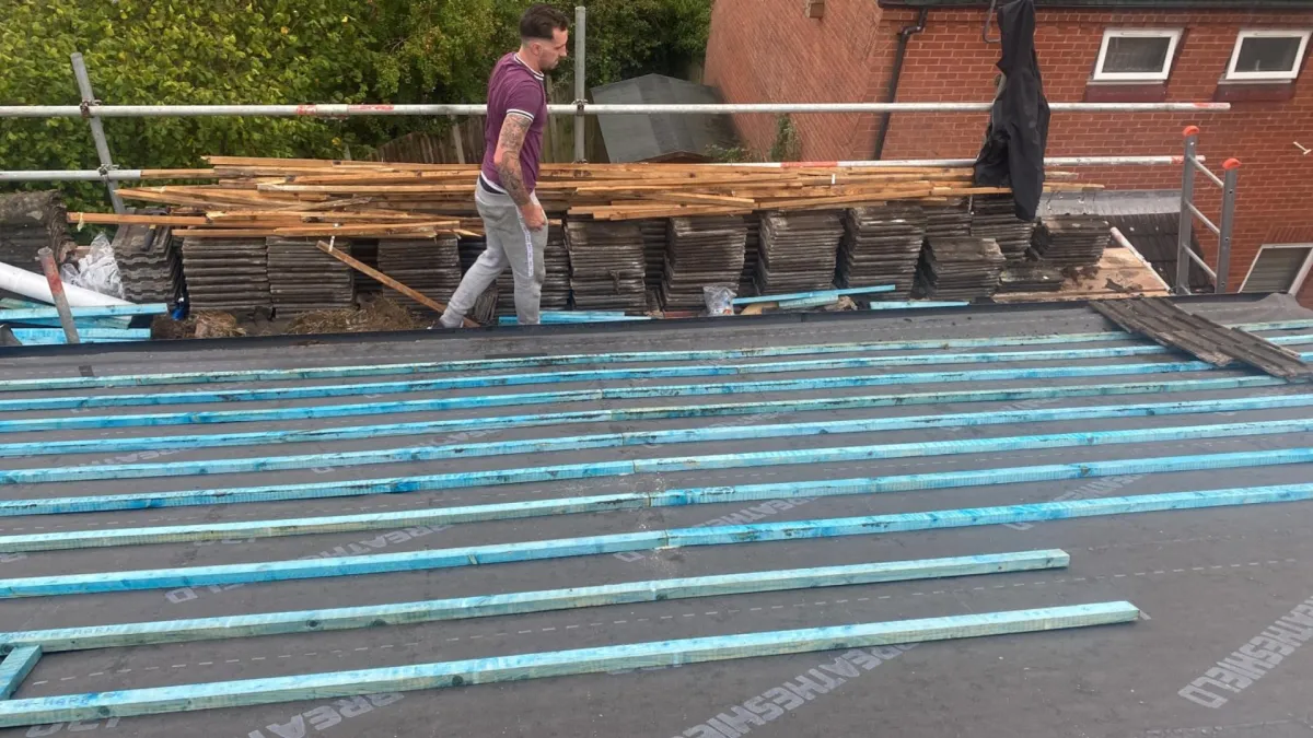 Roofer preparing for a roof repair or replacement, equipped with tools and safety gear, demonstrating readiness for professional roofing services by JF Roofers.