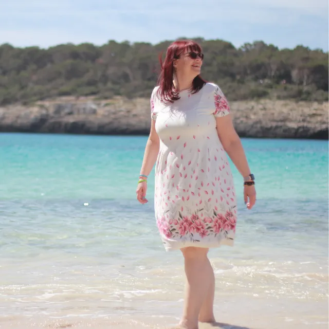 Marion Schumann im Sommerkleid im türkisen Meer, über stille Stärke im Sommer mit Lipödem