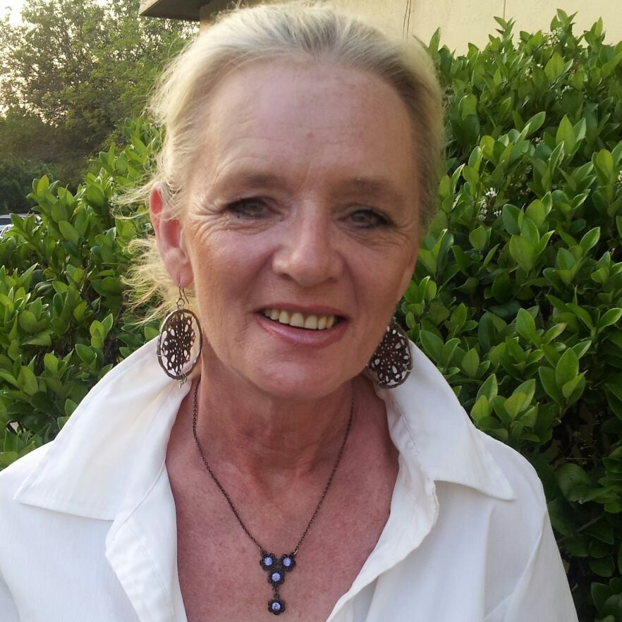 Portrait photo of Sally (BonerHead) smiling warmly outdoors.