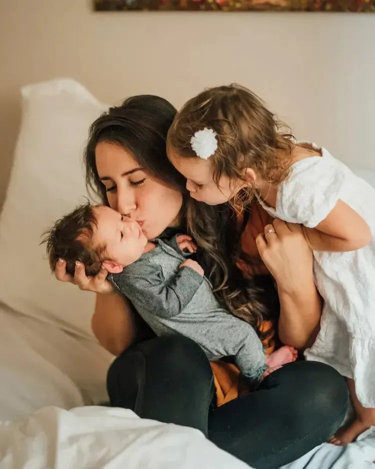 Newborn baby resting comfortably with postpartum support nearby