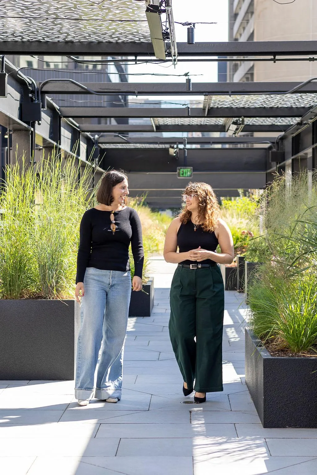 Alyssa Sharp, business and life coach, smiling and walking with a client — helping women leave 9–5 burnout and start coaching businesses.”