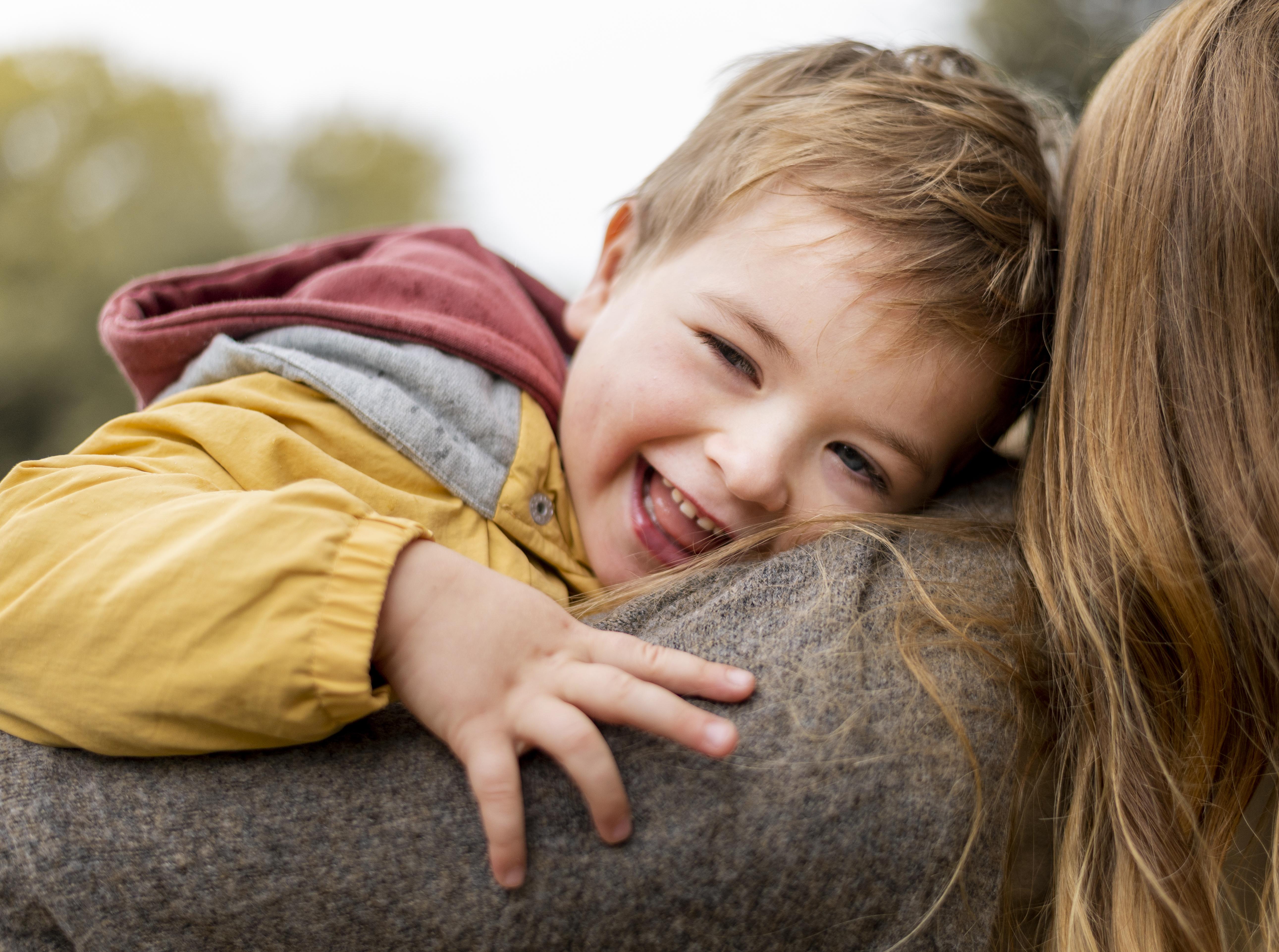 Niño feliz del reencuentro con su madre después del cole