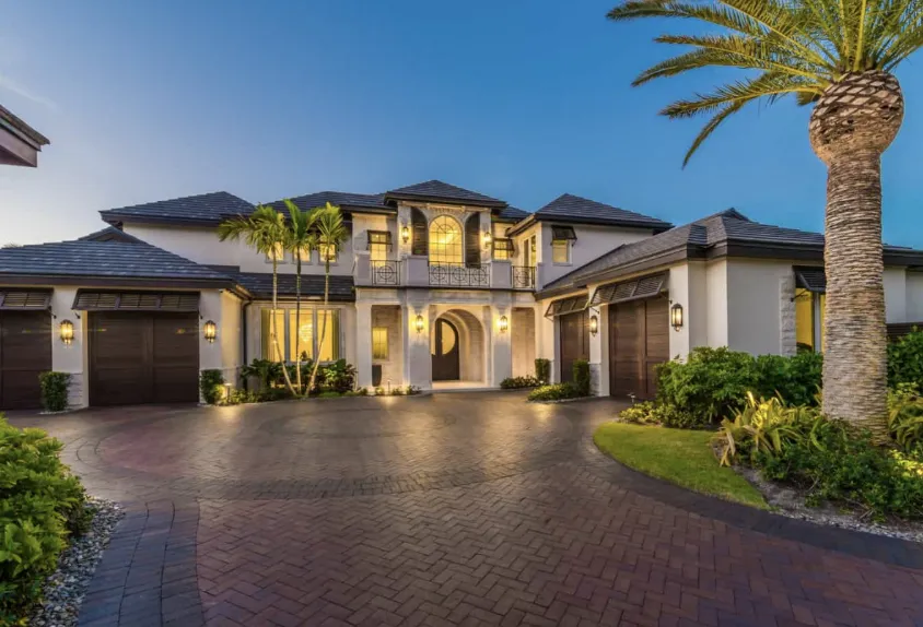 A house with a wooden fence and palm trees