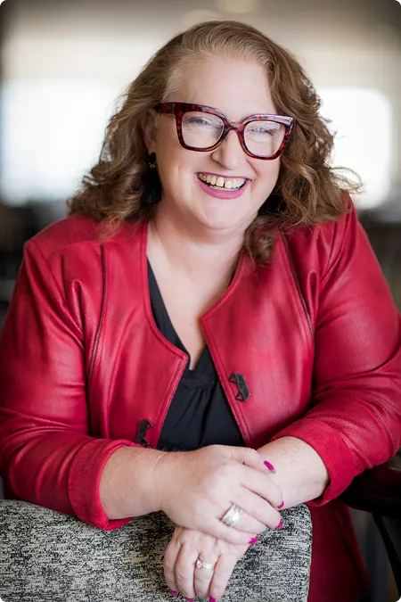 Portrait of Dannella Burnett smiling, wearing a red jacket