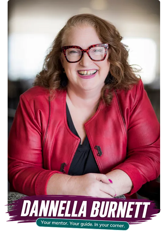 Portrait of Dannella Burnett, a smiling woman with glasses and red lipstick wearing a red jacket