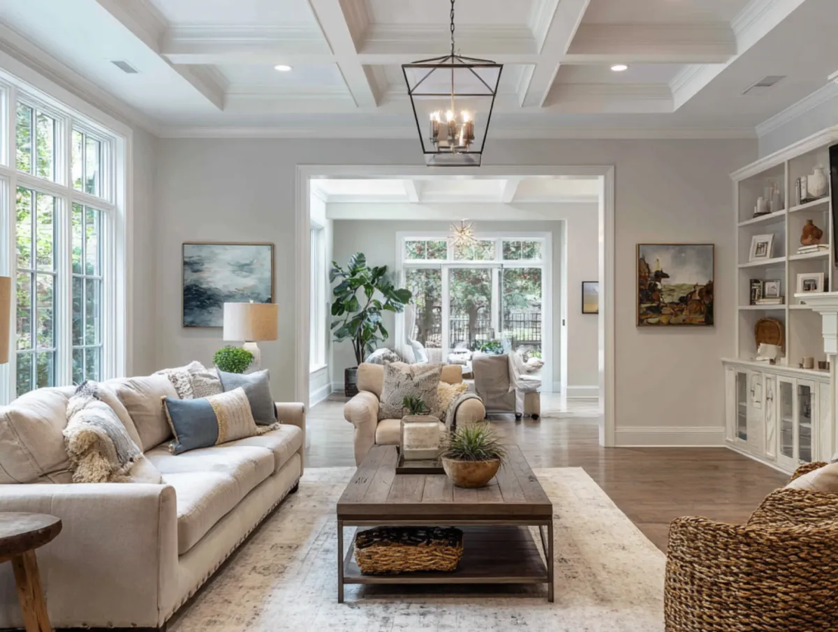 Professional handyman repairing kitchen cabinet in modern white kitchen providing expert home repair and maintenance services for homeowners in North Carolina
