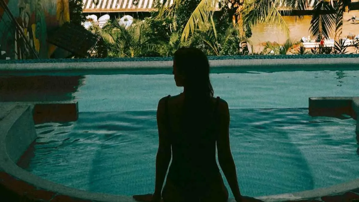 A woman standing in a tranquil pool at dusk, symbolizing introspection and intimacy from the Two Perspectives series