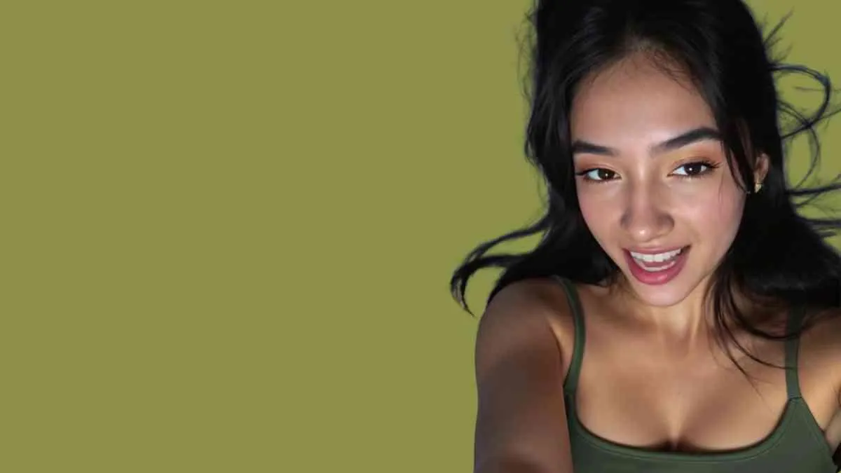 Young woman smiling directly at camera with natural confidence, representing playful intimacy and presence
