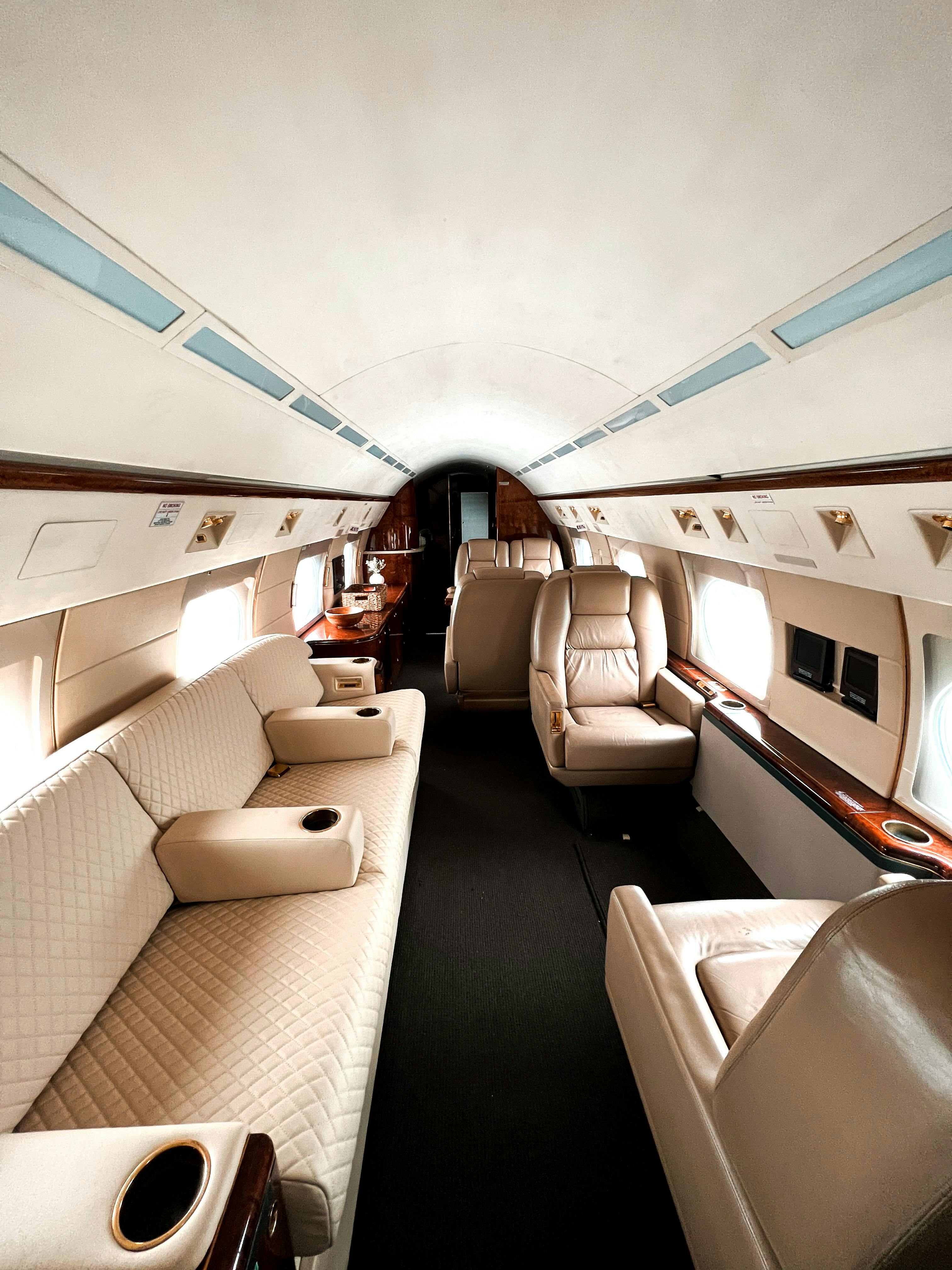 Luxury private jet cabin interior with leather seating and wood trim