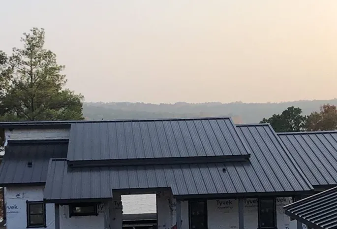 A picture of a home that's still under construction with a brand new metal roof on it. The home overlooks a beautiful valley in east Texas.