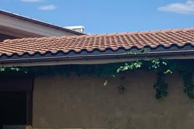 A picture dark orange, almost brown, Spanish style shingles from a completed roof repair job at a commercial location outside of Tyler, Texas.
