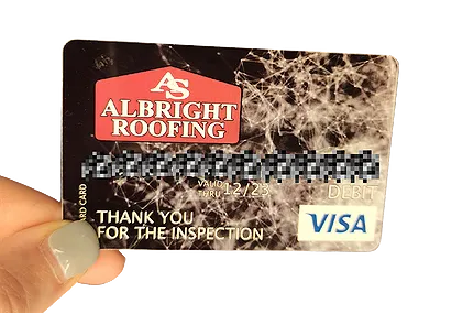A picture of a woman's hand holding a $25 Visa gift card that Albright roofing gives out as part of our referral program.