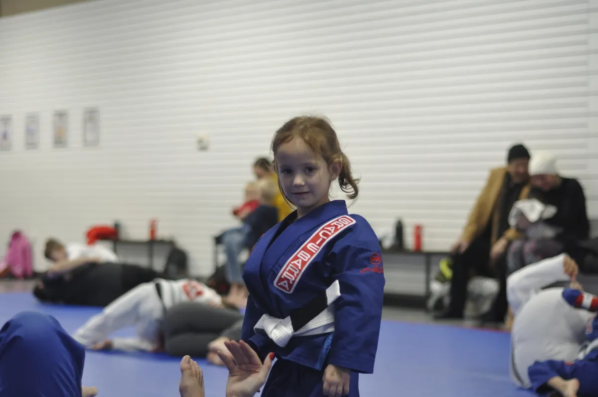 A nude dancer performs a complex movement on the floor.