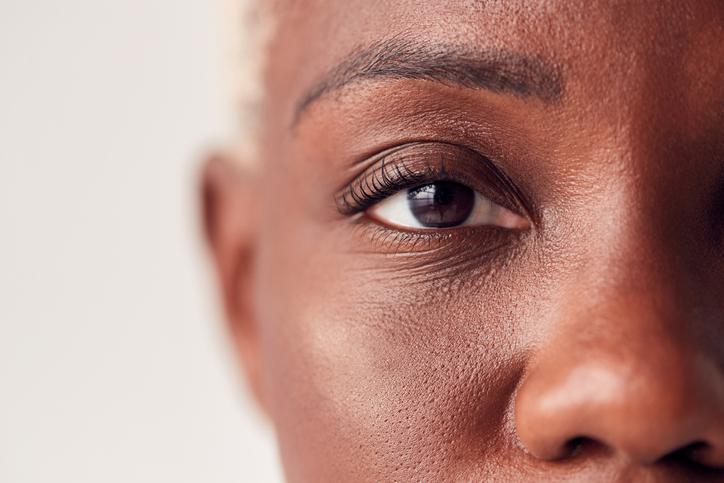 Close-up of a woman’s eye, representing focused, trauma-informed 1:1 coaching support.