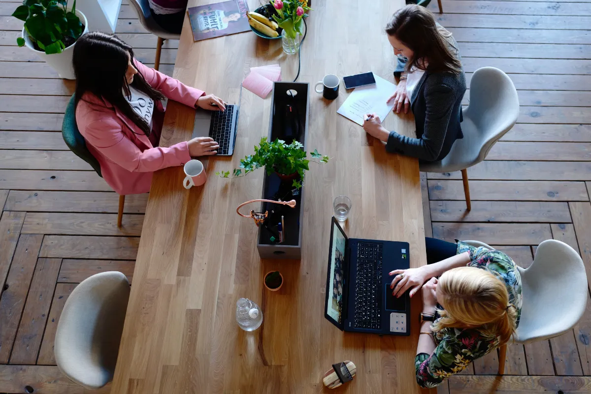 Solopreneurs collaborating at a shared desk, representing the spirit of connection and reciprocity in the Solo Time Bank.