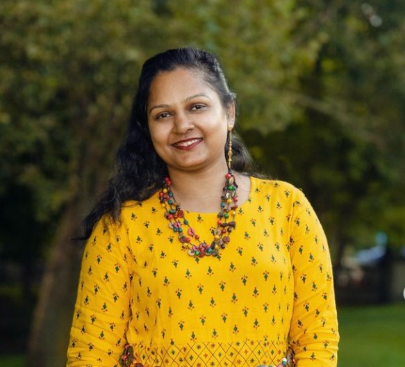 Professional henna artist creating intricate, natural plant-based designs for an adult event.