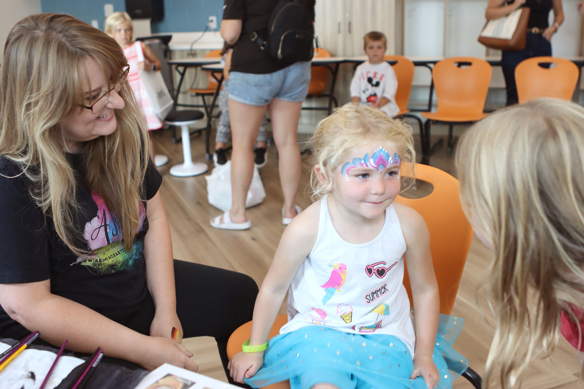 Creative artists working with kids at a local Columbus Ohio event, highlighting face painting job opportunities.