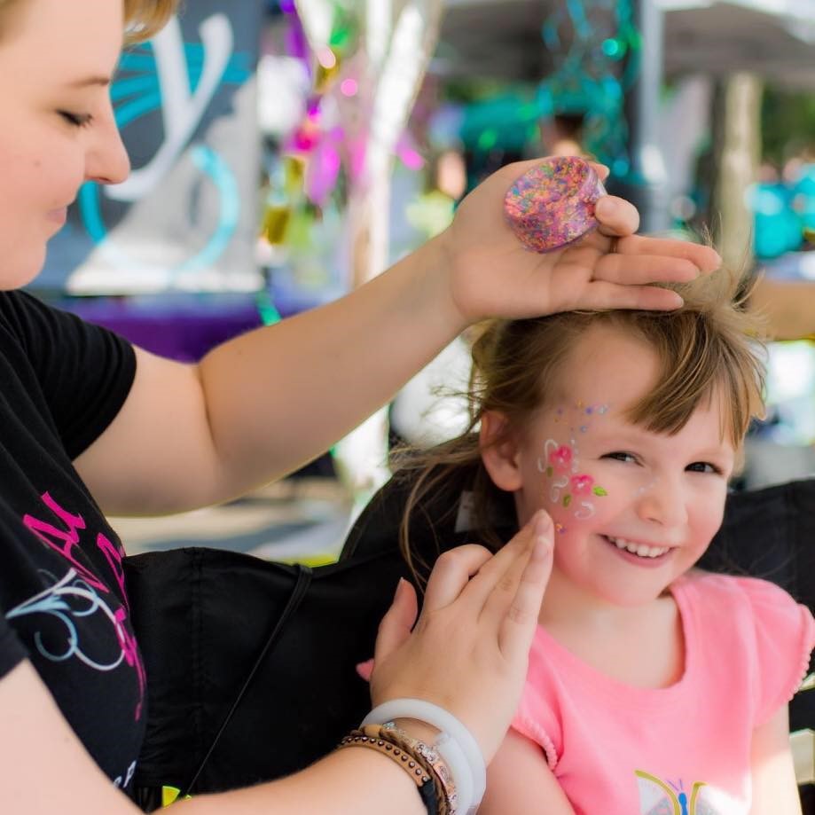 Aria Face Artistry team member face painting a happy child, showcasing creative party entertainment services in Central Ohio.