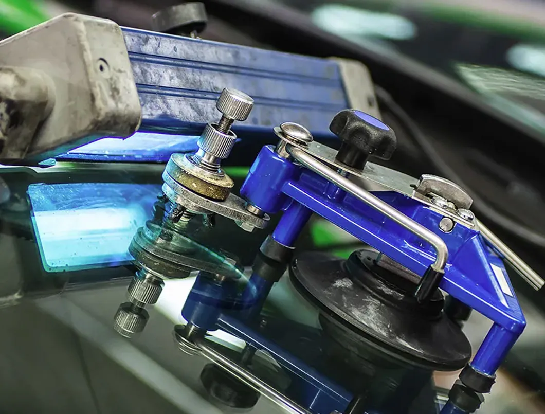 Windscreen chip repair tool injecting resin into cracked glass