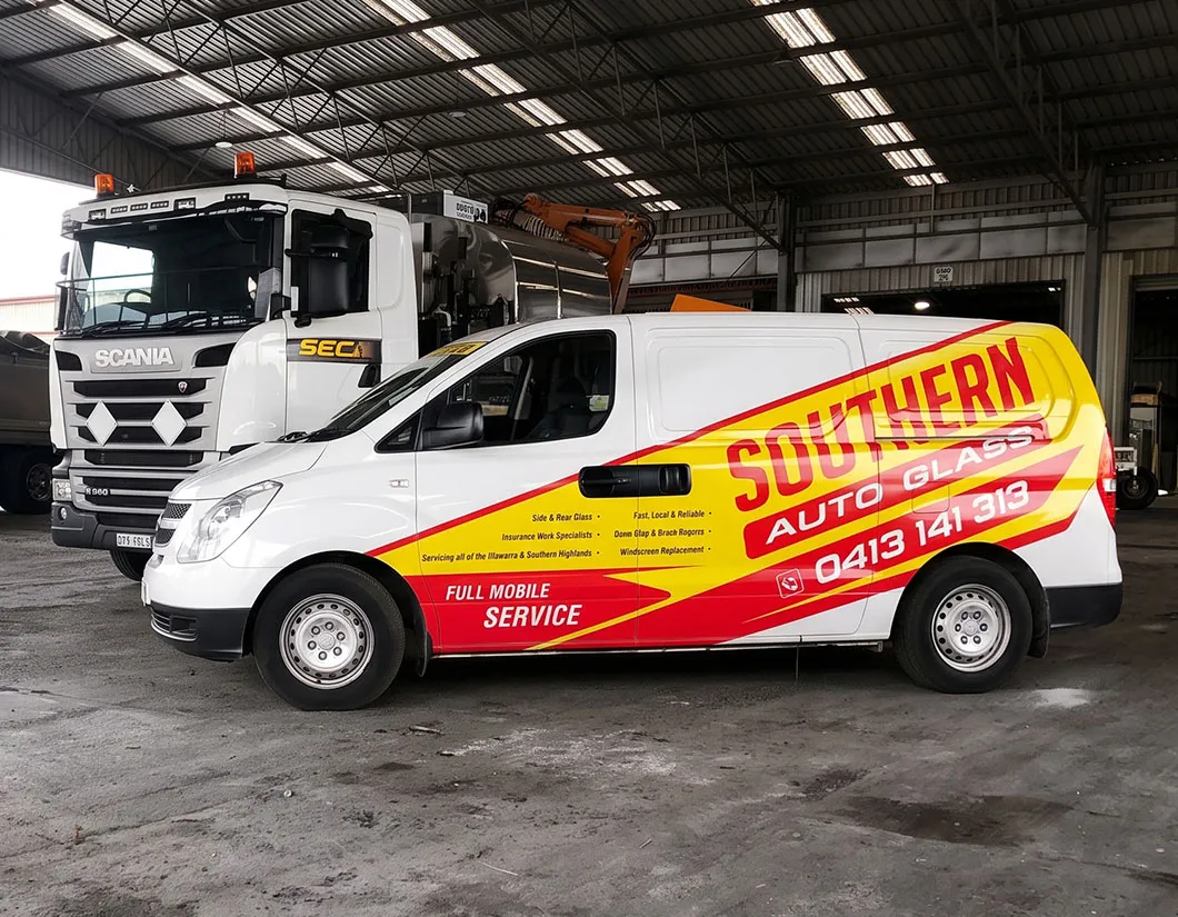Southern Auto Glass branded mobile van beside a Scania truck in the workshop