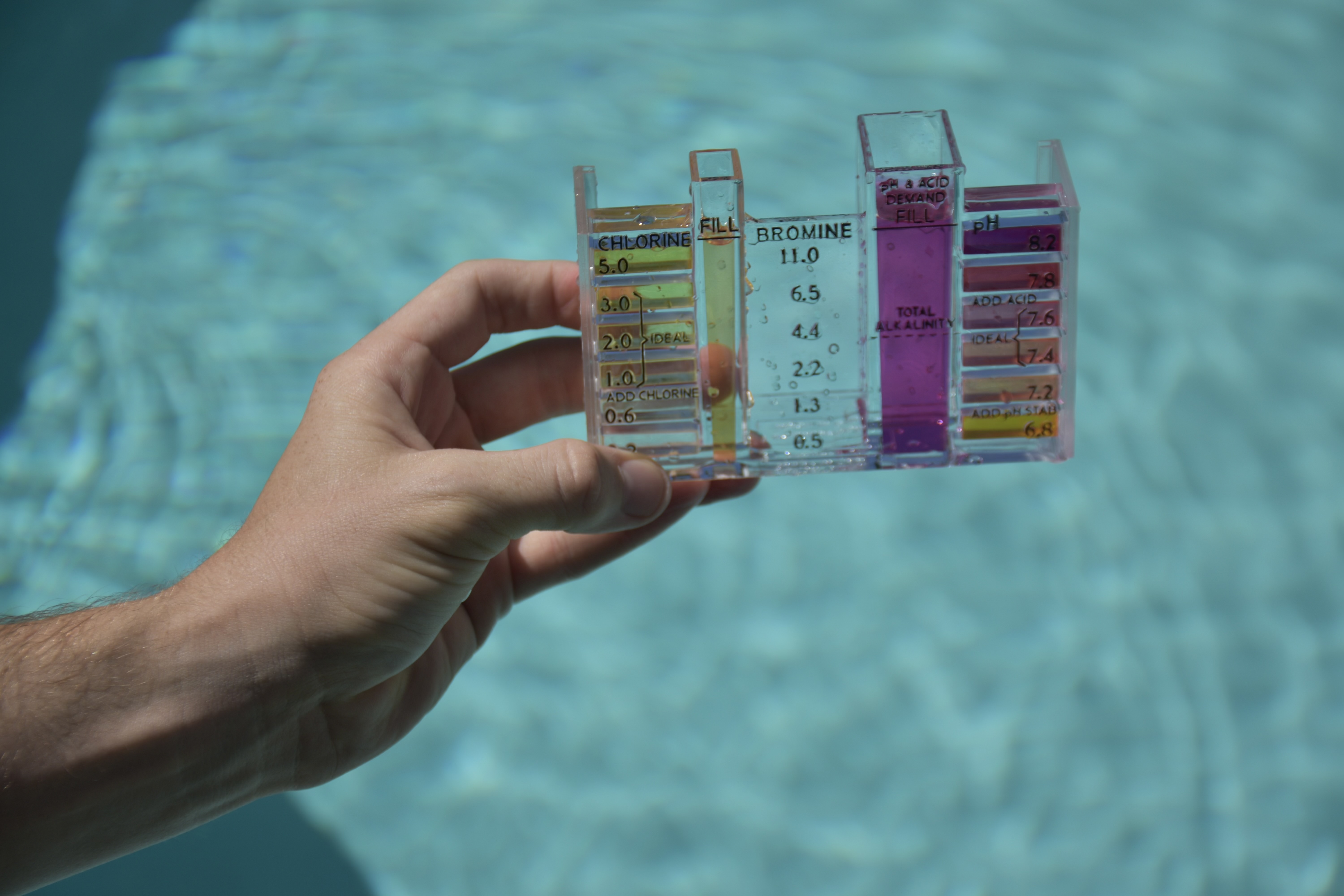Technician taking water samples for pool water testing.