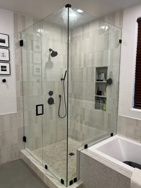 primary bathroom remodel with vertical tile, three stacked niches, matte black fixtures, and a framed in bathtub