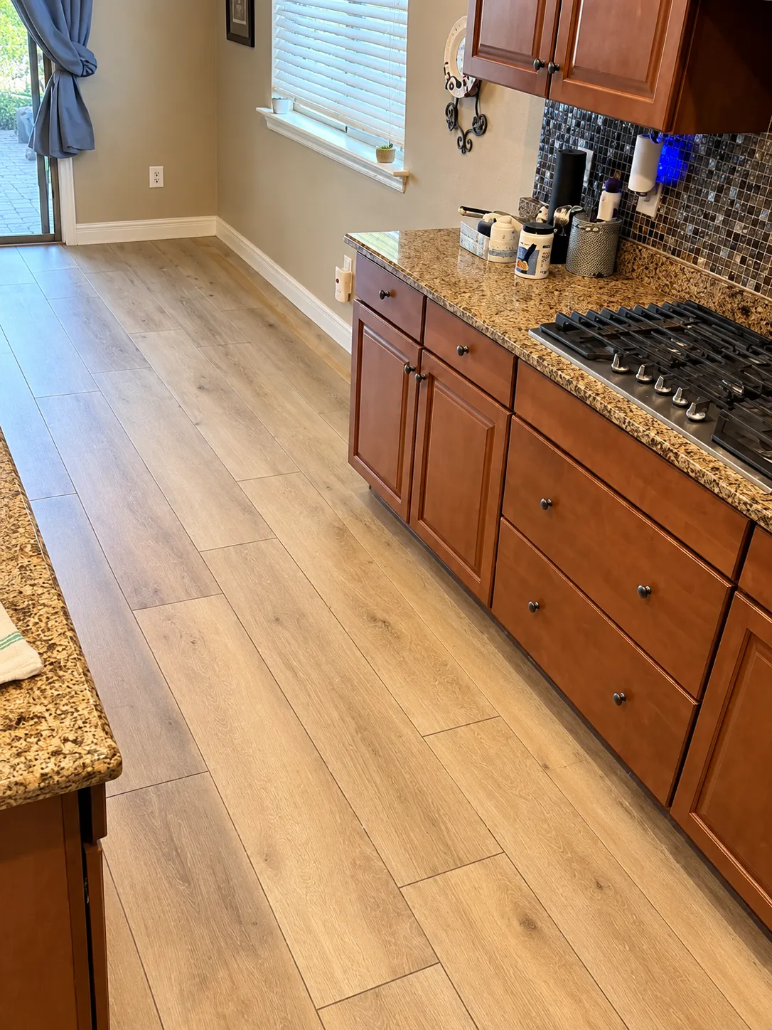 Wood-plank tile installed on the floor in a home, with the photo showing the kitchen