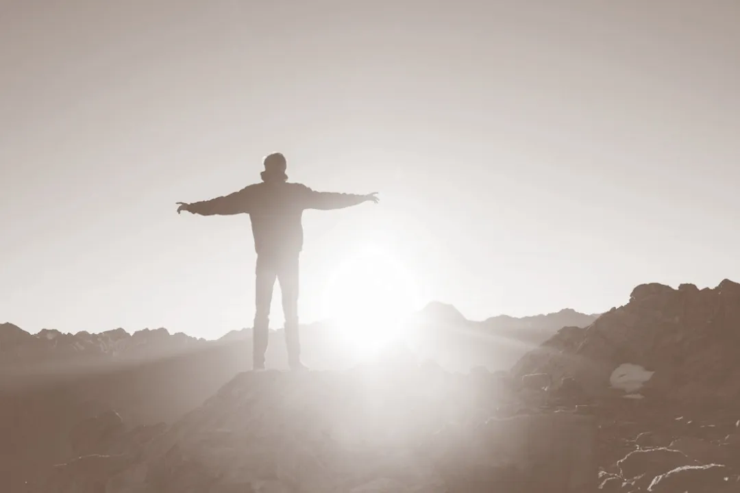 Person on a mountain top at sunrise
