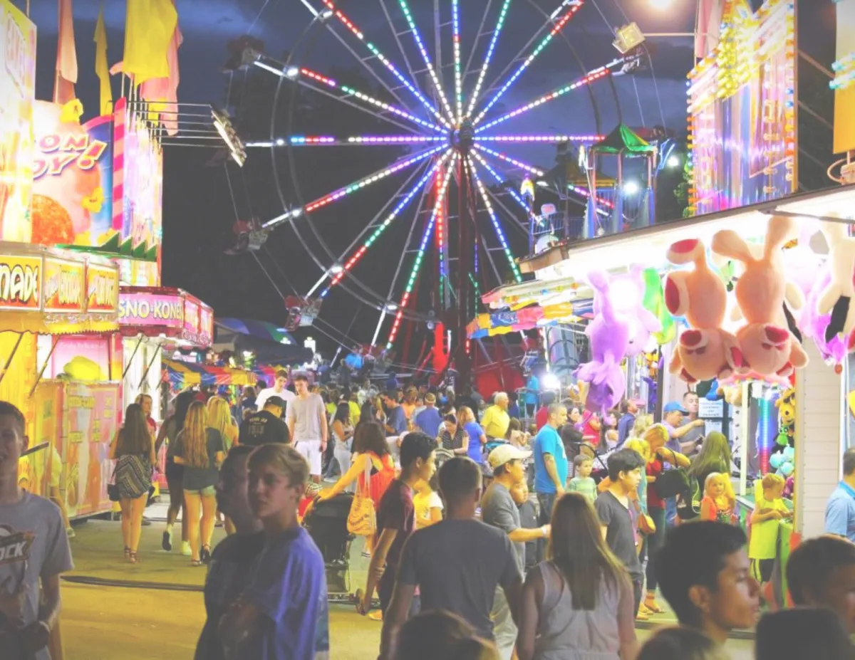 Crowds enjoying lights and carnival rides at the Rooster Days Festival in Broken Arrow.
