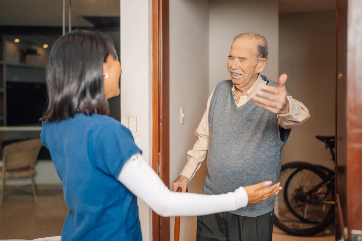 Carer and elderly patient hugging 